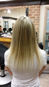 Back view of Amber's blonde fusion hair extensions after work was done to color correct and give her the length she desired.