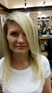 Front view of Amber's blonde fusion hair extensions after work was done to color correct and give her the length she desired.