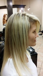 Side view of Amber's blonde fusion hair extensions after work was done to color correct and give her the length she desired.